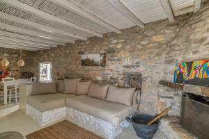 un soggiorno con divano in un muro di pietra di Villa Finca - Atypical a Pounda