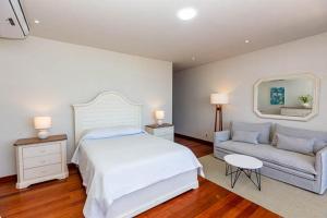 - une chambre avec un grand lit et un canapé dans l'établissement Hotel Boutique Caleta Grau, à Zorritos