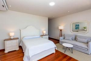 1 dormitorio con 1 cama grande y 1 sofá en Hotel Boutique Caleta Grau, en Zorritos