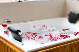 a bath tub filled with red petals in at Luxury Suites Prana By Cadissa in Medellín