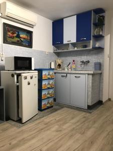 a kitchen with blue cabinets and a white refrigerator at Cozy loft apartment in Pleven