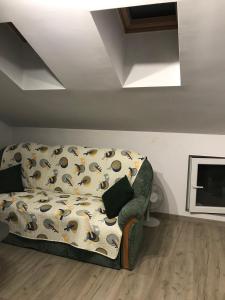 eine Couch in einem Wohnzimmer neben einem TV in der Unterkunft Cozy loft apartment in Plewen