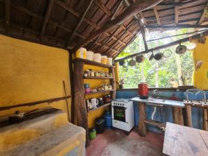 a kitchen with a stove and a sink in a room at Que Brota Do Chão in Itacaré