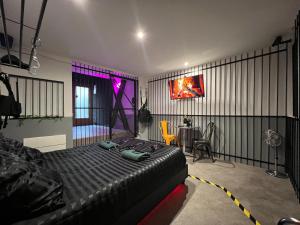 a bedroom with a bed and a dining room with a table at 50 nuances de gris - BDSM - Loveroom in Souppes-sur-Loing