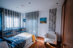 Villa Tiviti في أوفِييذو: غرفة نوم بها سرير وكرسي