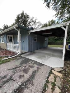 a house with a garage with a driveway at Cozy two bedroom home near downtown Shawnee in Shawnee