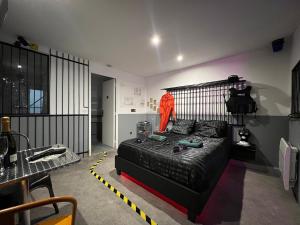 1 dormitorio con cama negra y mesa en 50 nuances de gris - BDSM - Loveroom en Souppes-sur-Loing