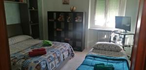 a small bedroom with two beds and a television at vercelli holiday house in Turin