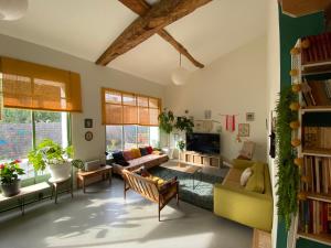 ein Wohnzimmer mit einem Sofa und einem Tisch in der Unterkunft Loft Saint-Jean in Monségur