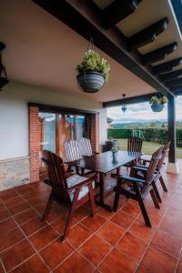 Une table et des chaises en bois sont disponibles sur la terrasse. dans l'établissement Villa Tiviti, à Oviedo