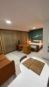 ヴィトーリアにあるPraia do Canto Apart Hotel quarto sala e varanda andar altoのベッドとソファのあるホテルの部屋