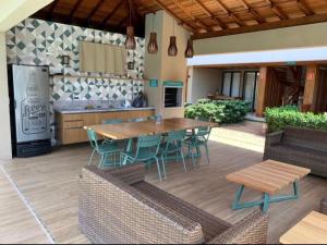 a patio with a table and chairs and a kitchen at Loft de praia - Itacimirim BAHIA in Itacimirim