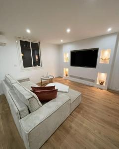 ein Wohnzimmer mit einem Sofa und einem Flachbild-TV in der Unterkunft T3 Haut standing in Saint-Raphaël
