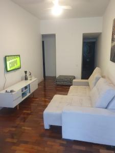 sala de estar con sofá blanco y TV en Melhor de Copacabana en Río de Janeiro