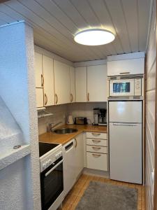 a kitchen with white cabinets and a white refrigerator at Casa Vierumäki in Vierumäki