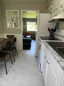 eine Küche und ein Esszimmer mit einem Tisch und einem Kühlschrank in der Unterkunft Modern & Cozy 2 bedroom home near downtown Shawnee in Shawnee