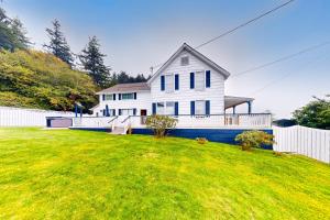 una casa blanca con una valla y un patio en Umpqua Overlook, en Reedsport