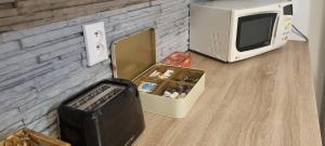 a microwave and a box on a table next to a tv at FAMILY Apartmán v centre mesta Bratislava in Bratislava