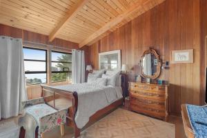 a bedroom with a bed and a mirror and a dresser at Rosemary's Retreat in Mendocino