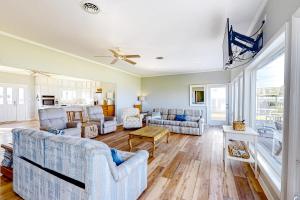 uma sala de estar com sofás e uma ventoinha de tecto em Living Water Estate em Atlantic Beach