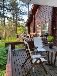 um deque com cadeiras, uma mesa de piquenique e uma casa em Casa Vierumäki em Vierumäki