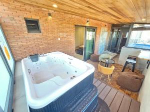 a large bath tub in a room with a brick wall at Brooch Boutique Hotel in Tbilisi City
