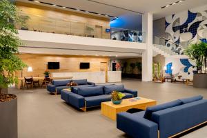 eine große Lobby mit blauen Sofas und einem Tisch in der Unterkunft Lagune Barra Hotel in Rio de Janeiro