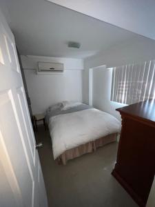 a bedroom with a bed in a white room at Cómodo apartamento entero in Caracas