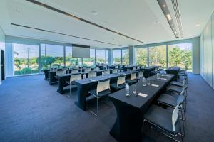 a conference room with tables and chairs and windows at Lagune Barra Hotel in Rio de Janeiro
