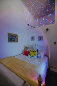 a bedroom with a bed with a smiley face pillow on it at CITY RETRO GUAYAMA in Guayama