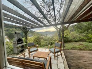 patio con mesa, sillas y fogones en Cosy Chalet au cœur du Sidobre avec Piscine et Spa, en Vabre