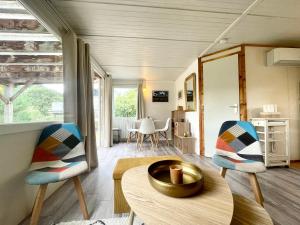 ein Wohnzimmer mit 2 Stühlen und einem Tisch in der Unterkunft Cosy Chalet au cœur du Sidobre avec Piscine et Spa in Vabre