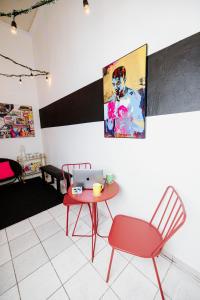 a room with a table and a red chair and a laptop at CITY RETRO GUAYAMA in Guayama