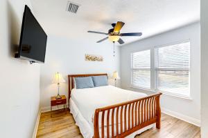 a bedroom with a bed and a ceiling fan at Ocean's Shimmer Sanctuary in Panama City