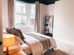 a bedroom with a bed and a window at Rosslyn House by Solace Stays in Newport