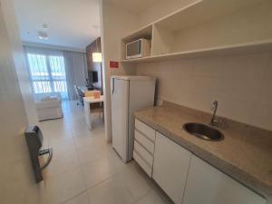 a kitchen with a sink and a refrigerator at Flat Fusion Express By Rei dos Flats in Brasilia