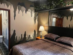 um quarto com uma cama e uma parede com morcegos pintados em Belize Budget Suites em San Pedro