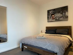 sypialnia z łóżkiem i lustrem w obiekcie Luxury en-suite room Olympic Village in shared apartment w Londynie