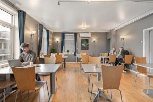 restauracja z ludźmi siedzącymi przy stolikach z laptopami w obiekcie Enter Backpack Hotel w mieście Tromsø