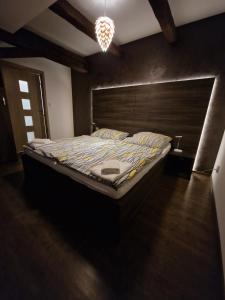 una camera da letto con un letto grande con testiera in legno di Apartmány pod Klášterem a Kladruby