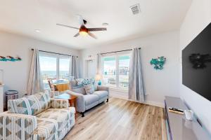 un soggiorno con un divano e un ventilatore a soffitto di Couple's Getaway, 2nd floor ocean view suite w/ beautiful sunrises, patio, AC a Flagler Beach