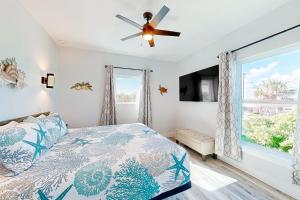 una camera da letto con un letto e un ventilatore a soffitto di Couple's Getaway, 2nd floor ocean view suite w/ beautiful sunrises, patio, AC a Flagler Beach