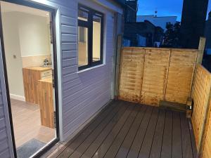 a wooden deck with a door and a sink at Cosy Studio Flat with Balcony in Heart of London in London