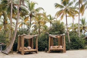 2 camas en la playa con palmeras en Playa Koralia, en Buritaca