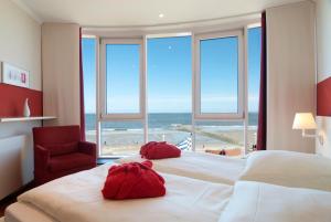 Schlafzimmer mit einem großen Bett und Strandblick in der Unterkunft Strandhotel Georgshöhe in Norderney + 37 Fotos