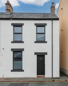 una casa bianca con finestre nere e una porta di Southend Cottage a Penrith