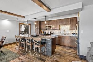 a kitchen with wooden cabinets and a large island with bar chairs at Corinthian Circle - Dillon in Dillon