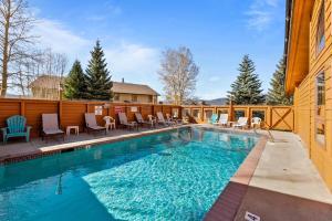 a swimming pool with chairs and a fence at Corinthian Circle - Dillon in Dillon