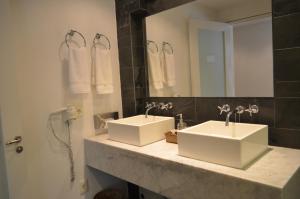 a bathroom with two sinks and a mirror at Hotel Boutique Casagrande in Paysandú