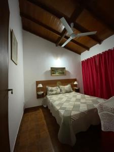 Un dormitorio con una cama y un ventilador de techo. en Complejo Quimey No se alquila a jóvenes y se reserva con el 30 porciento del total mediante depósito bancario, en Villa Gesell